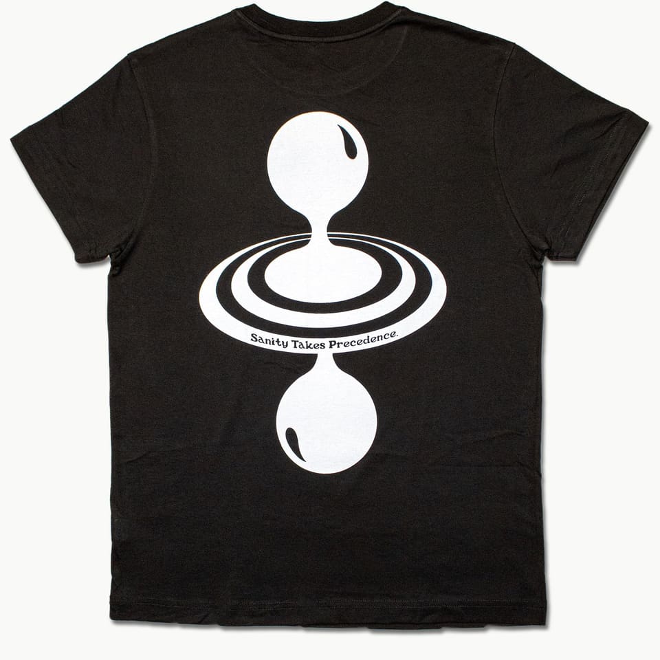 Back of a black tee with a large white print of a drop falling into ripples and the words 'Sanity Takes Precedence'.